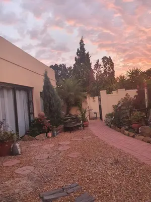 a yard with a building and a fence and a patio at DOTJJ B & B in Paarl