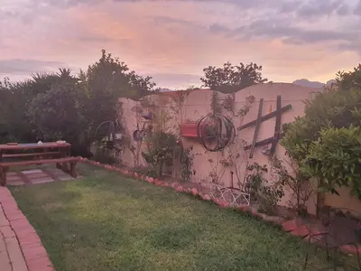 a garden with a bench and a wall with graffiti at DOTJJ B & B in Paarl