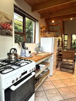 a kitchen with a white stove and a refrigerator at Theebos in Strand