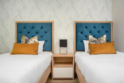 a bedroom with two beds and a blue headboard at Dolphin Beach E30 in Cape Town