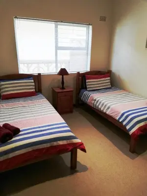 a bedroom with two beds and a window at C the C - Holiday Home in Hermanus