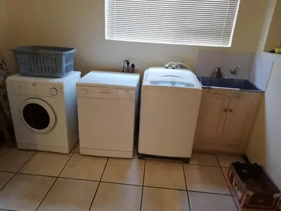 a laundry room with a washer and dryer and a sink at C the C - Holiday Home in Hermanus