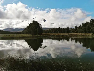 a lake with a reflection of clouds in the water at Hoogwater Garden Cottage in Wolseley