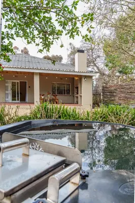 a house with a swimming pool in front of a house at Hoogwater Garden Cottage in Wolseley