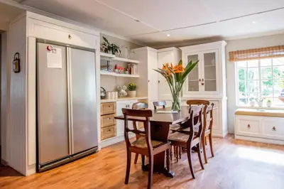 a kitchen with a table and chairs and a refrigerator at Hoogwater Farmhouse in Wolseley