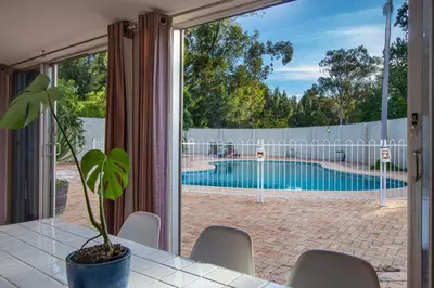 a house with a swimming pool seen through a window at Hoogwater Farmhouse in Wolseley