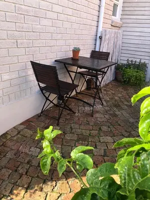 a picnic table and two chairs on a patio at The West Wing guest suite. Pringle Bay. in Pringle Bay