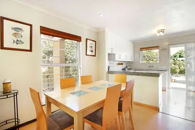 a kitchen and dining room with a table and chairs at Kwantu Guesthouse 1 in Cape Town