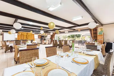 a dining room with white tables and chairs at Kwantu Guesthouse 1 in Cape Town