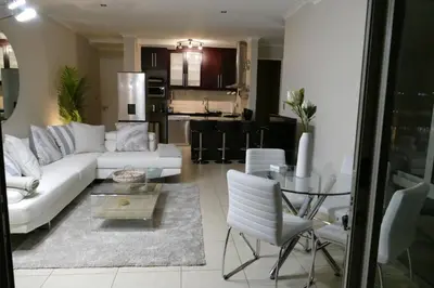 a living room with a white couch and a glass table at Little Venice Self Catering in Bellville