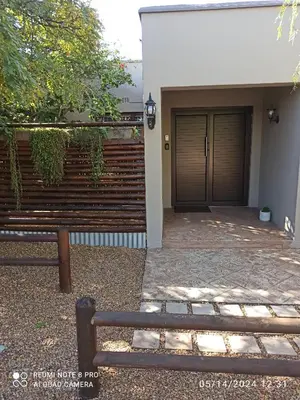a wooden bench sitting in front of a house at 17Peppertree in Cape Town