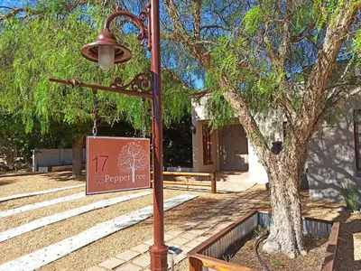a street light with a sign next to a tree at 17Peppertree in Cape Town