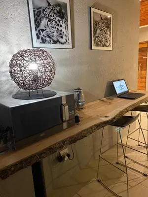 a table with a microwave and a laptop on it at On the GBay Villa in Gordonʼs Bay