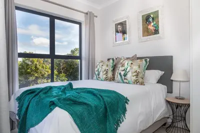 a bedroom with a bed with a large window at 6 Atlantic Port - Cosy, modern 2-bedroom apartment - Blouberg in Bloubergstrand