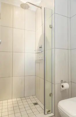 a shower with a glass door in a bathroom at 6 Atlantic Port - Cosy, modern 2-bedroom apartment - Blouberg in Bloubergstrand