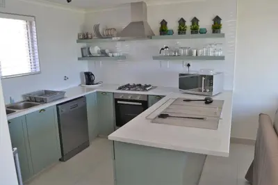 a kitchen with green cabinets and a white counter top at Hermanus Beach Club - Le Maree House 18 in Hermanus