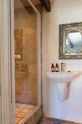 a bathroom with a sink and a shower at Old Potters Inn in Greyton