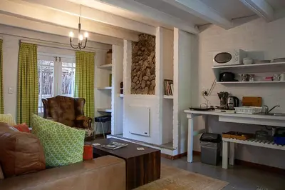 a living room with a couch and a table at Old Potters Inn in Greyton