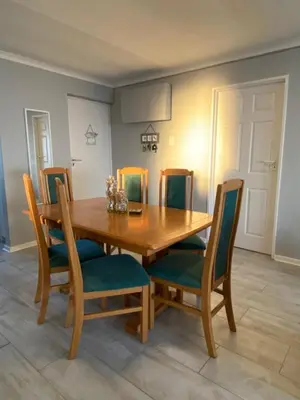 a dining room table with chairs and a wooden table at CView in Hermanus