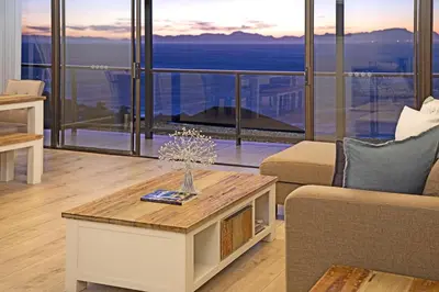 a living room with a couch and a table at Zaria Sun Penthouse in Cape Town