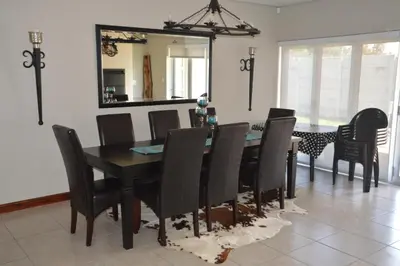 a dining room with a table and chairs and a mirror at Piece of Paradise in Hermanus