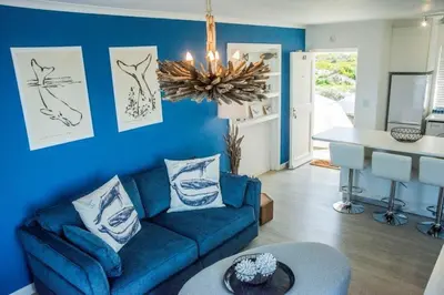a blue living room with a blue couch and a table at Whale Rock 40 in Hermanus