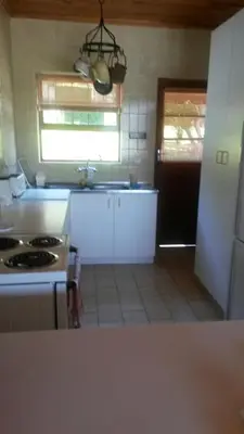 a kitchen with a sink and a stove top oven at Lagoon Edge in Hermanus