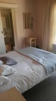 a bedroom with a large white bed with a window at Lagoon Edge in Hermanus