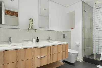 a bathroom with two sinks and a toilet at Matrix Apartments in Cape Town