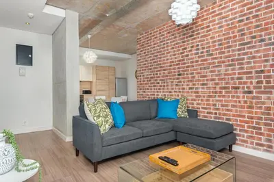 a living room with a couch and a brick wall at Matrix Apartments in Cape Town