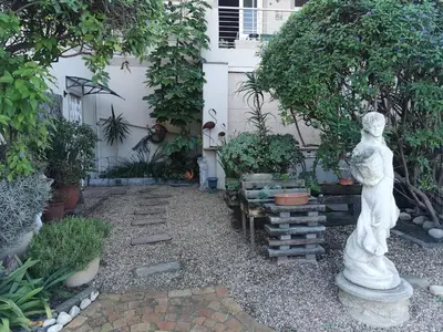 a garden with a statue in front of a house at Guinea Fowl Self Catering in Cape Town