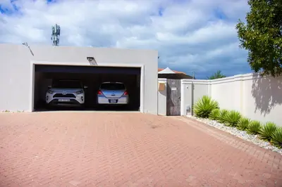 two cars are parked in a garage at Wilcre's blouberg home in Cape Town