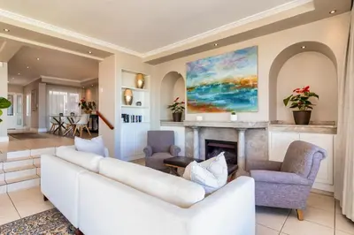 a living room with a white couch and a fireplace at Hermanus Beachfront Lodge - Solar Power in Hermanus