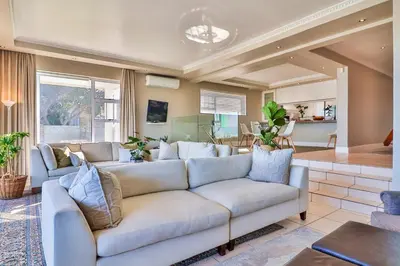 a living room with a couch and a table at Hermanus Beachfront Lodge - Solar Power in Hermanus