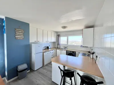 a kitchen with white cabinets and a wooden counter top at Ocean View Apartment in Cape Town