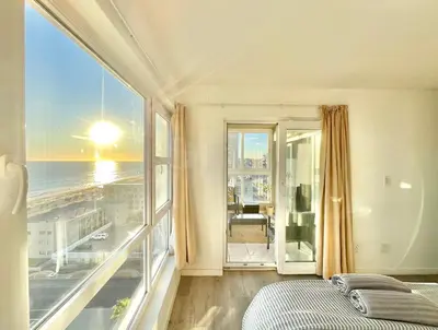 a bedroom with a balcony with a view of the ocean at Ocean View Apartment in Cape Town