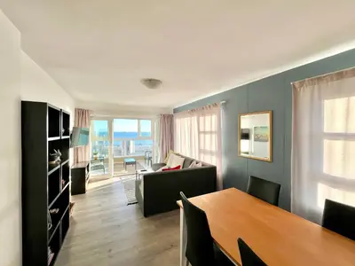 a living room with a table and a couch at Ocean View Apartment in Cape Town
