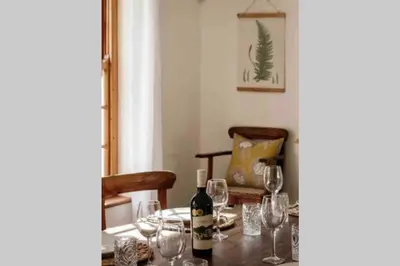 a dining room table with wine bottles and glasses at De Goede Hoop Farmstead in Wilgerhof