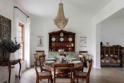 a dining room with a table and chairs and a chandelier at De Goede Hoop Farmstead in Wilgerhof