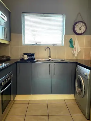 a kitchen with a sink and a washing machine at The CoziPlace in Cape Town
