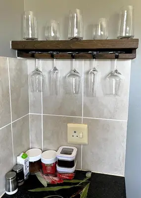 a kitchen with wine glasses on a wall at The CoziPlace in Cape Town