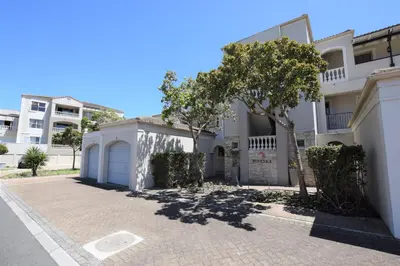 a white house with a garage and a tree at The CoziPlace in Cape Town