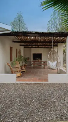 a patio with a swing and a house at Hoogwater Cottage in Wolseley