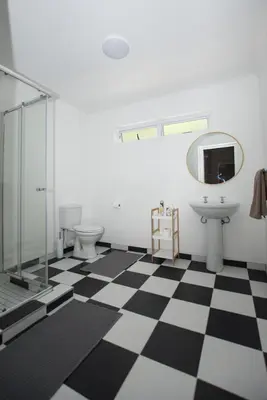 a bathroom with a black and white checkered floor at Hoogwater Family House in Wolseley