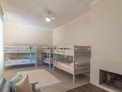 a room with three bunk beds and a fireplace at Hoogwater Family House in Wolseley