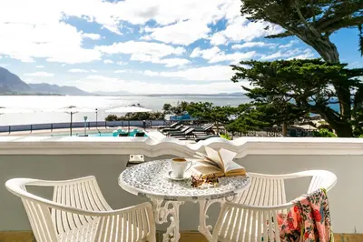 a table and chairs with a book on a balcony at Harbour House Hotel - Manor House in Hermanus