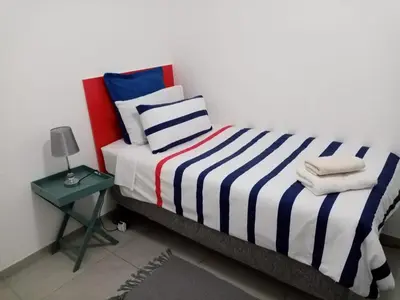 a bedroom with a bed with a blue and white striped blanket at Covenant Place in Cape Town