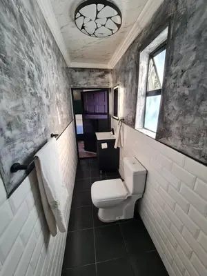 a bathroom with a toilet and a sink at Hoogeland's Wood Cabins in Eersterivier