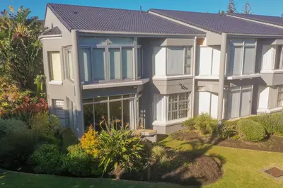 a large house with a garden in front of it at Milas Place Spacious & Comfortable at Bayview in Hermanus