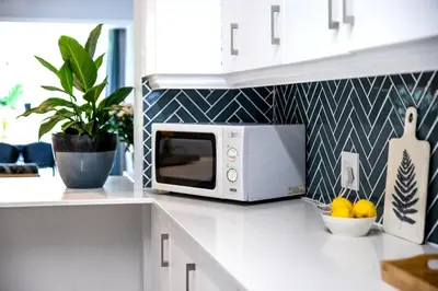 a kitchen with a white microwave on a counter at Milas Place Spacious & Comfortable at Bayview in Hermanus